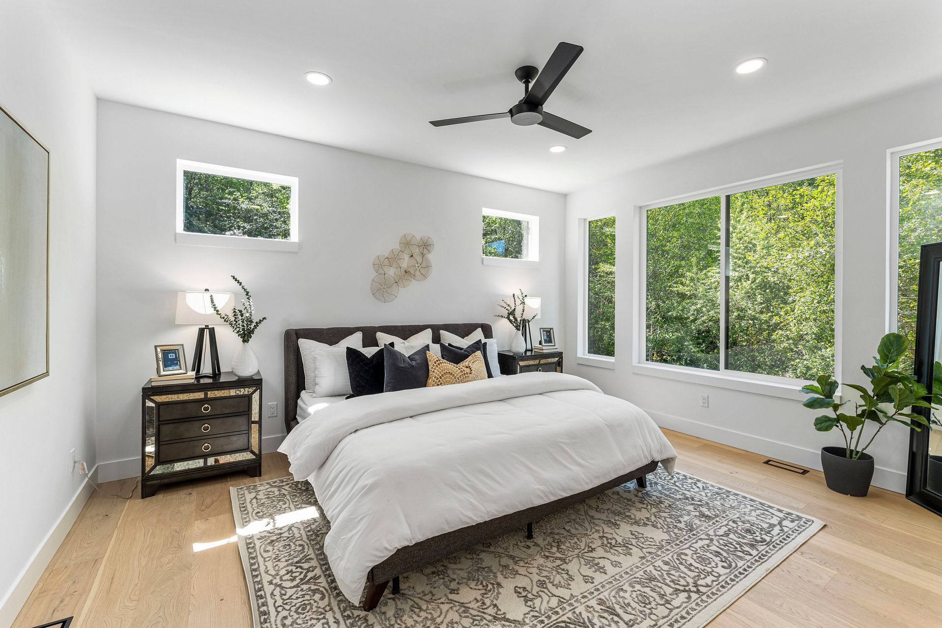 A bedroom with a large bed and a ceiling fan.