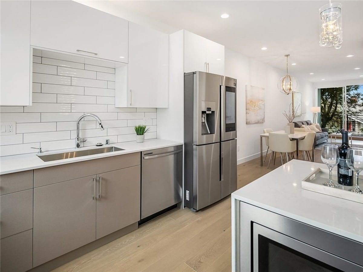 A kitchen with stainless steel appliances and white cabinets