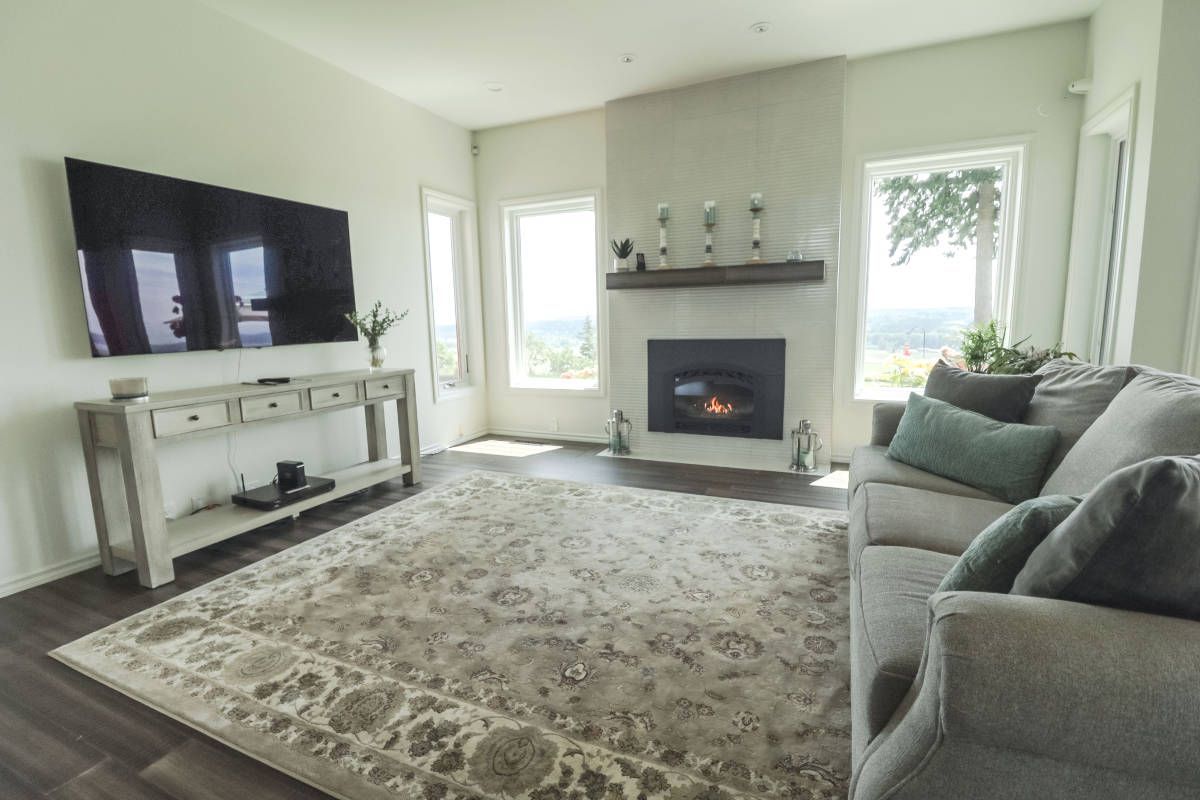 A living room with a couch , fireplace , television and rug.