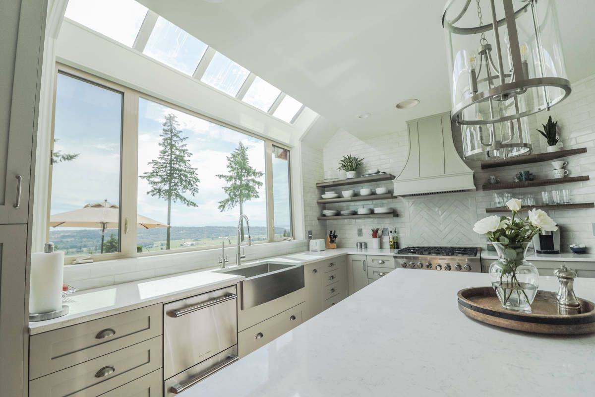 A kitchen with a large window overlooking the ocean.