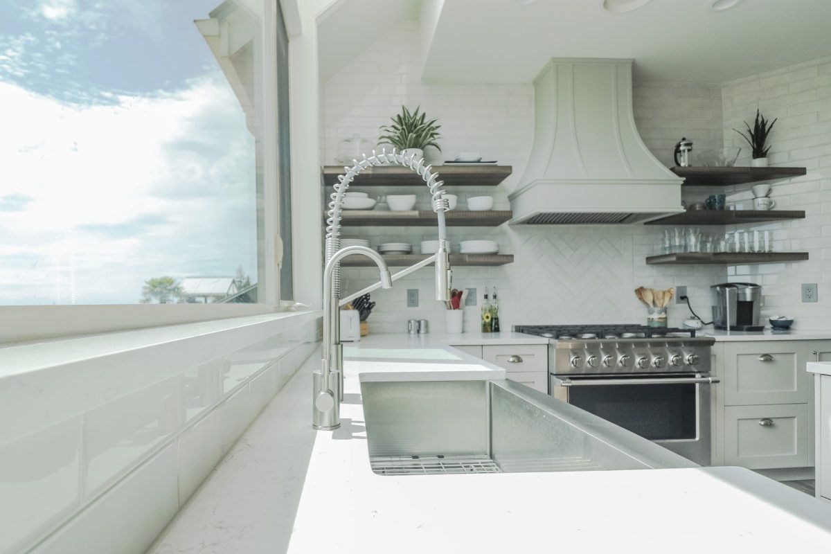 A kitchen with a sink , stove , and window.