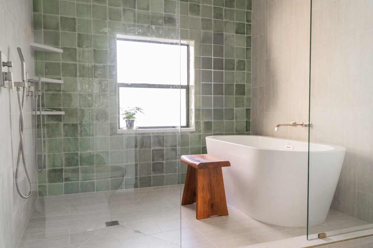 A bathroom with a bathtub , shower , and window.