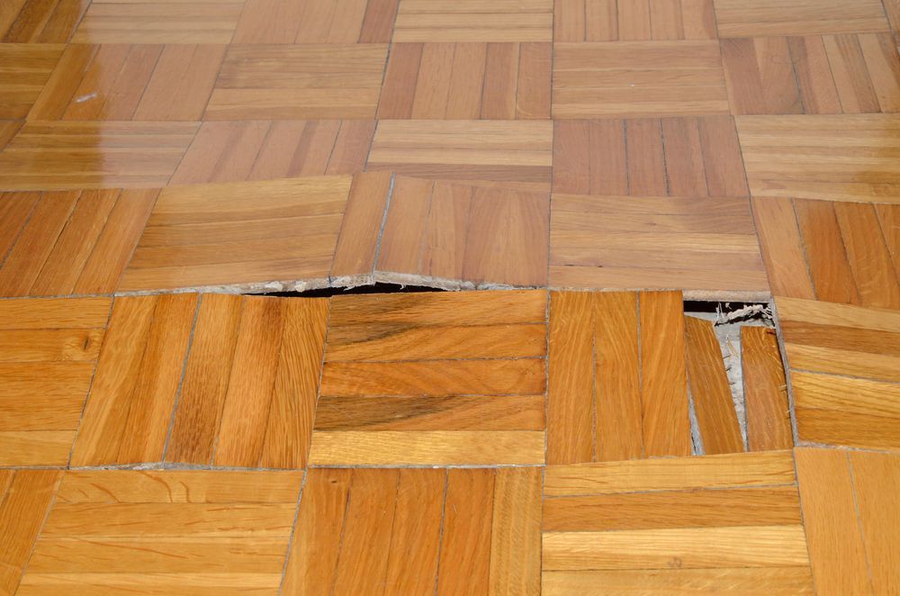 A close up of a wooden floor with a hole in it.