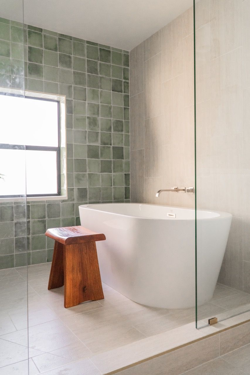 A bathroom with a bathtub and a wooden stool