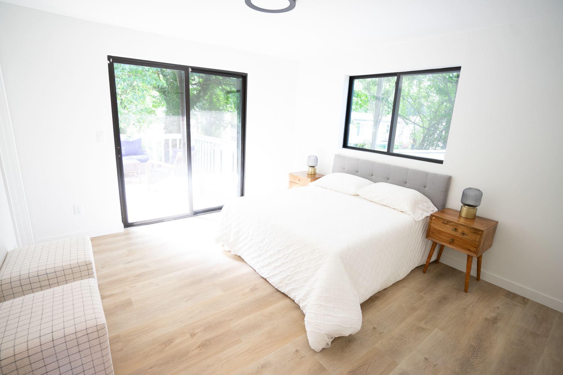 A bedroom with a bed , nightstand , and sliding glass doors.