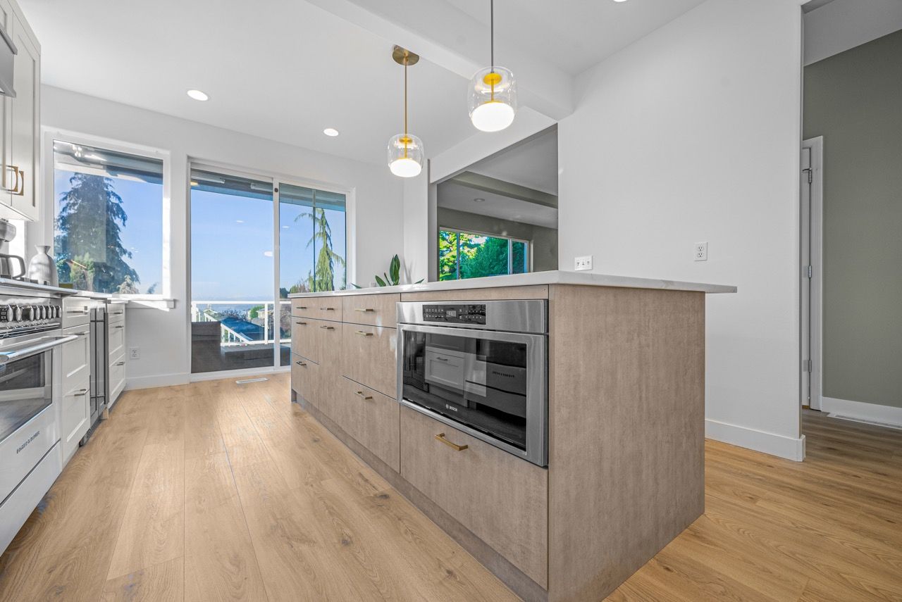 A kitchen with a large island and stainless steel appliances.