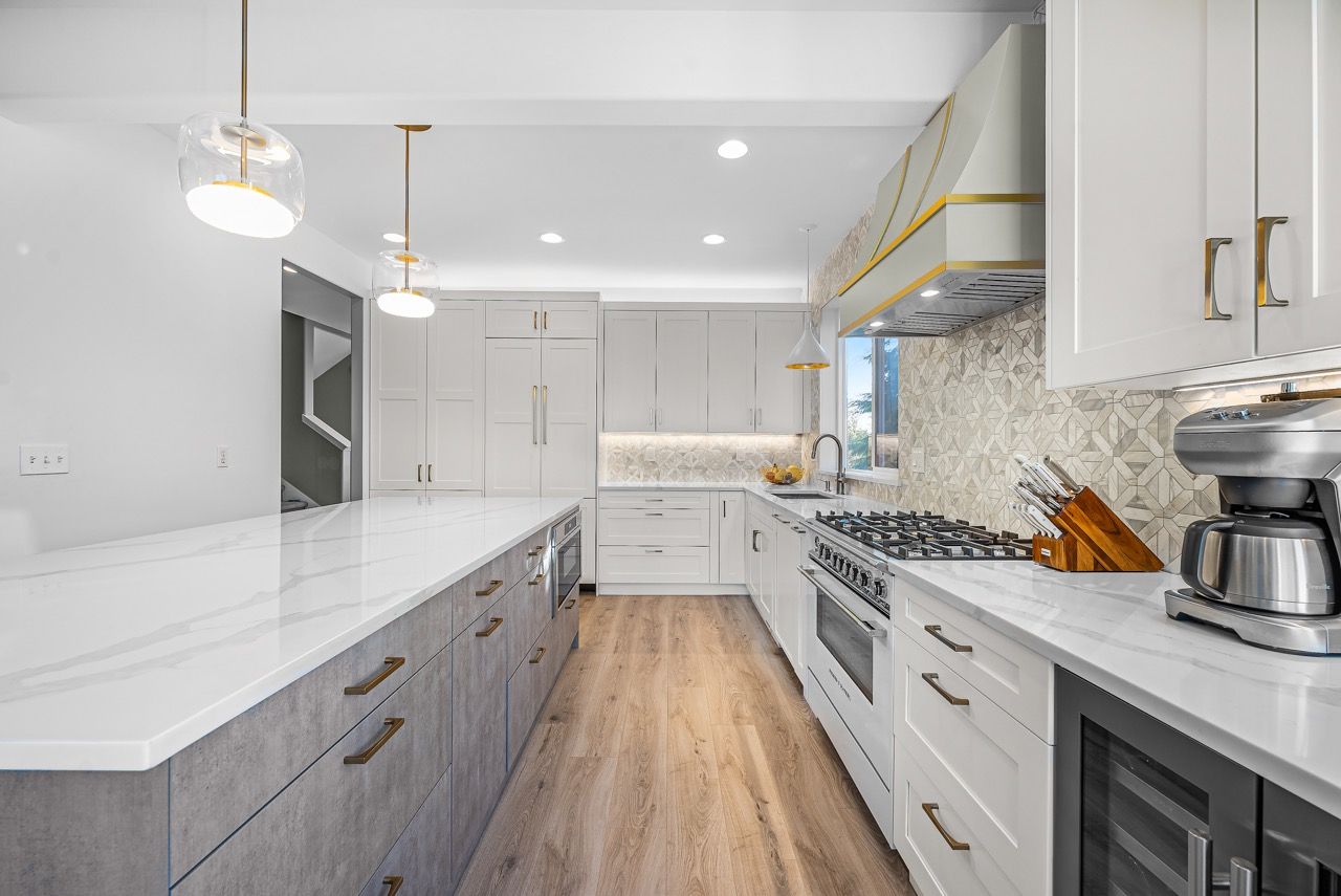 A kitchen with white cabinets , granite counter tops , stainless steel appliances and a coffee maker.
