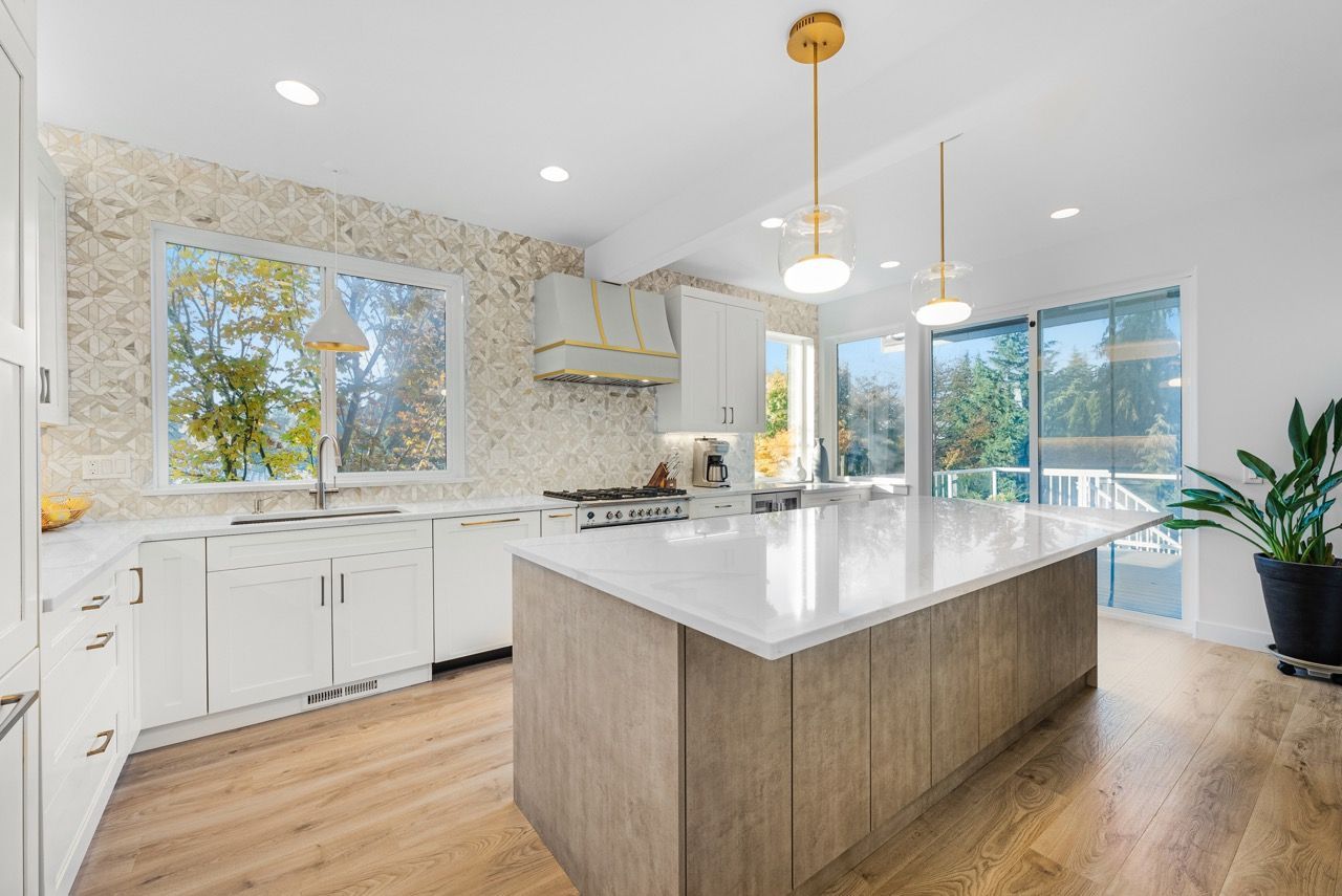 A kitchen with white cabinets and a large island in the middle.