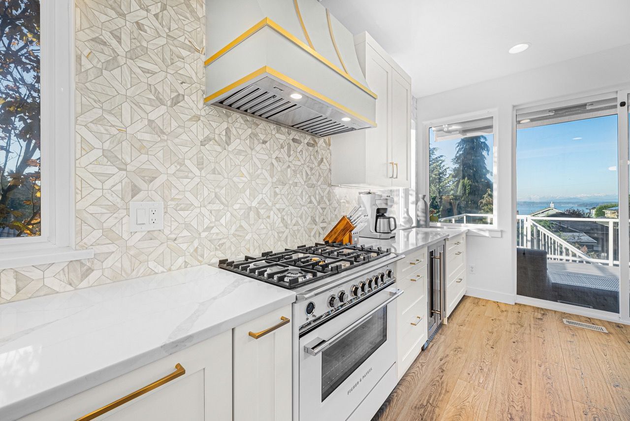 A kitchen with a stove , oven , sink , and sliding glass doors.