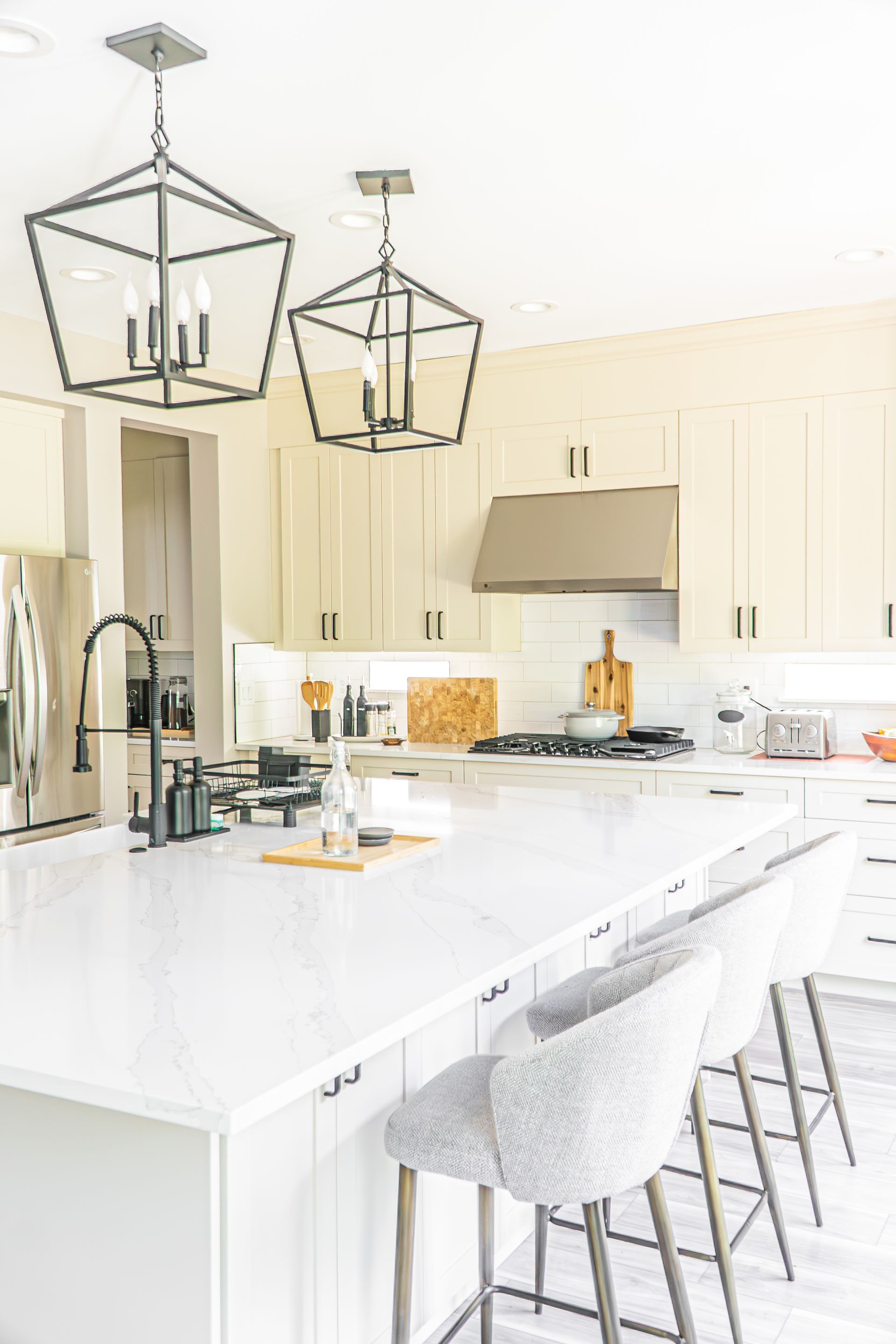 A kitchen with white cabinets , white counter tops , stainless steel appliances , and a large island.