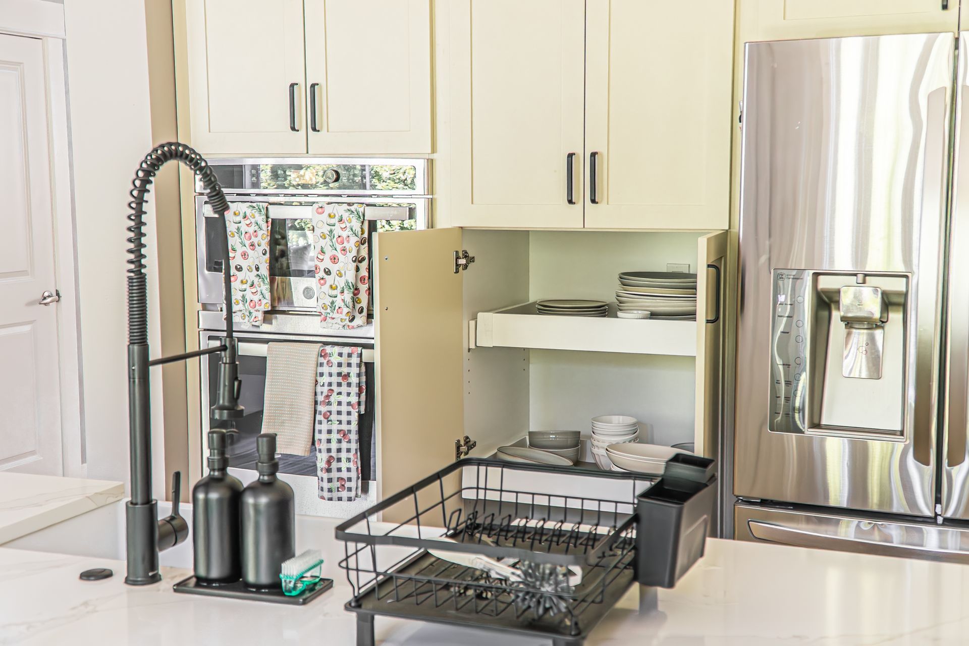A kitchen with a stainless steel refrigerator , sink , and dishwasher.
