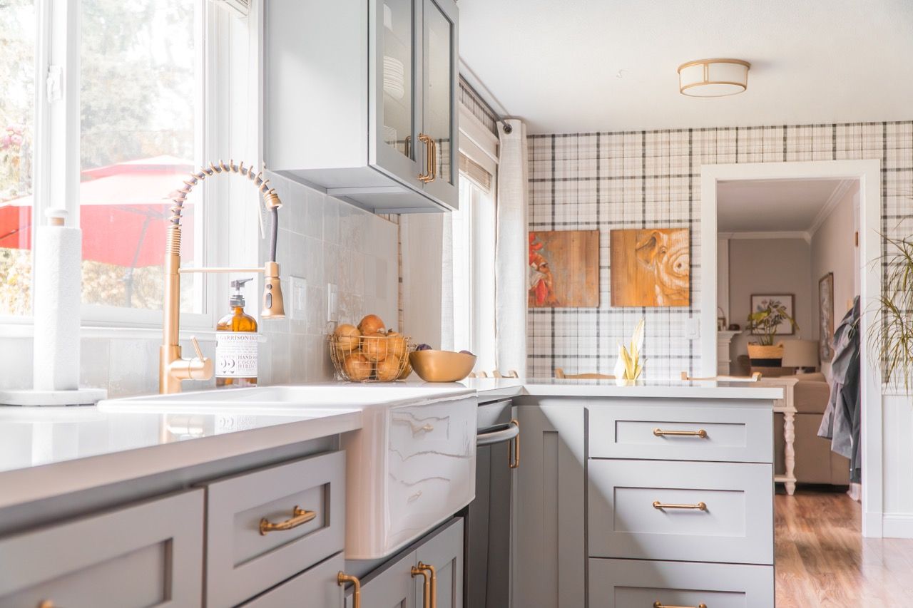 A kitchen with a sink , cabinets , drawers and a window.