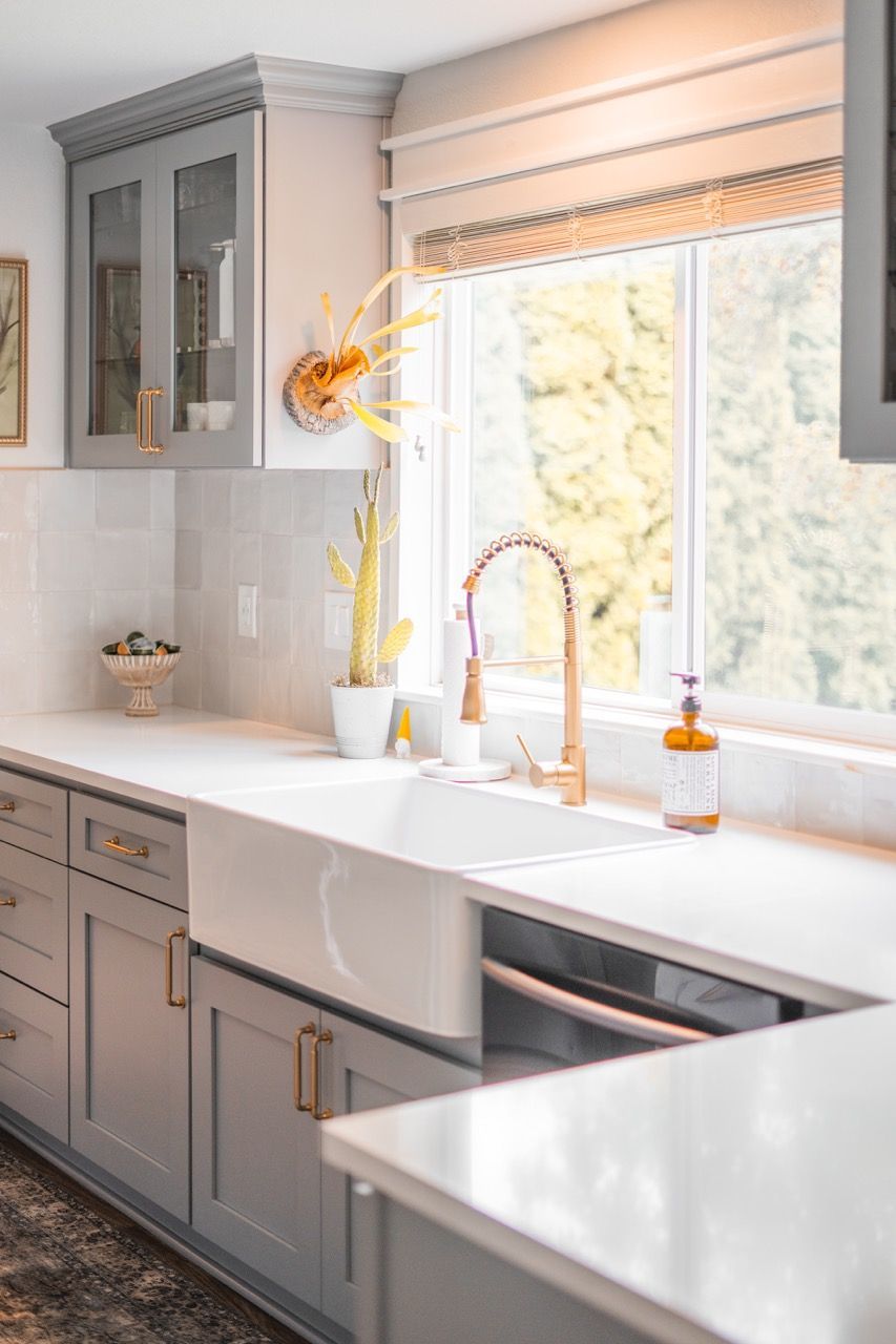 A kitchen with a sink , dishwasher , and window.