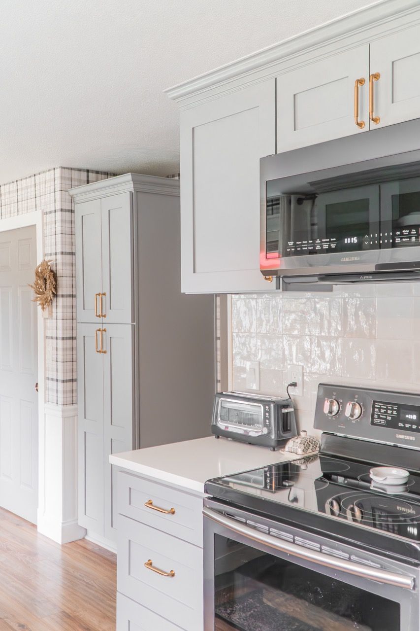 A kitchen with a stove , microwave , and toaster oven.