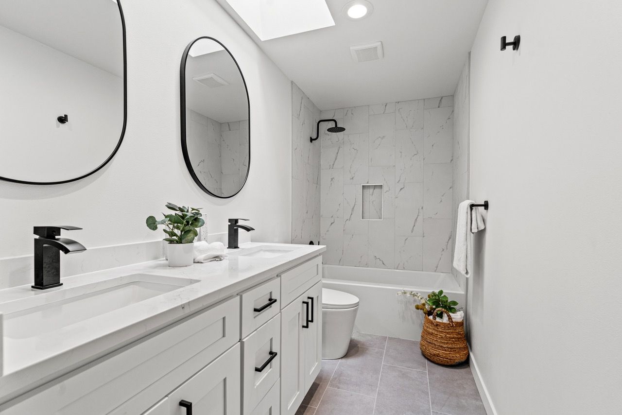 A bathroom with two sinks , a toilet , and a shower.