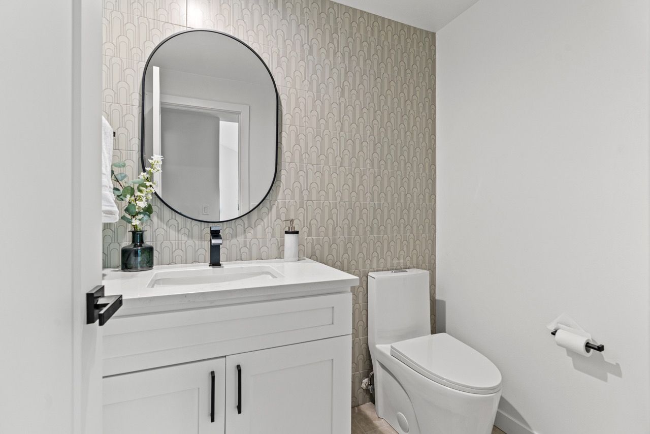 A bathroom with a sink , toilet and mirror.