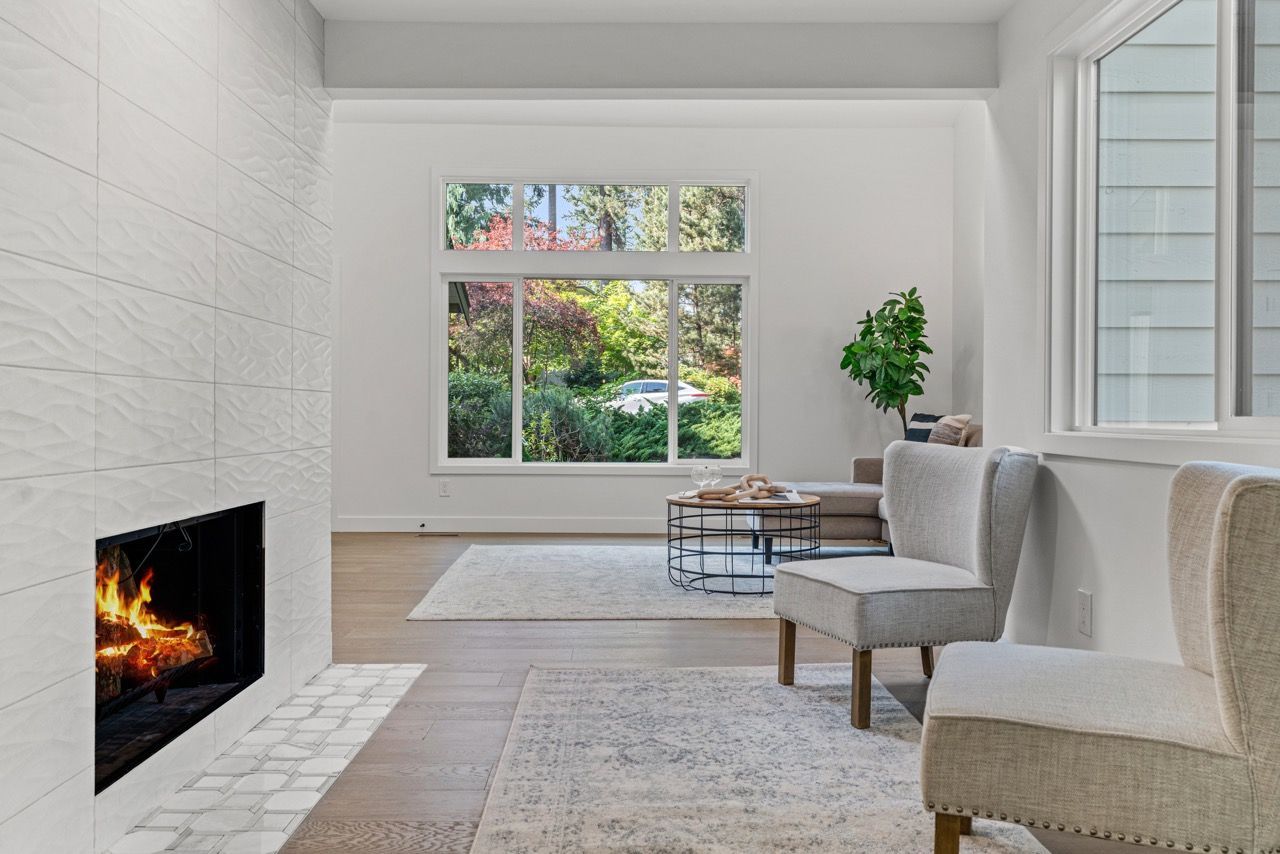 A living room with a fireplace , chairs and a couch.