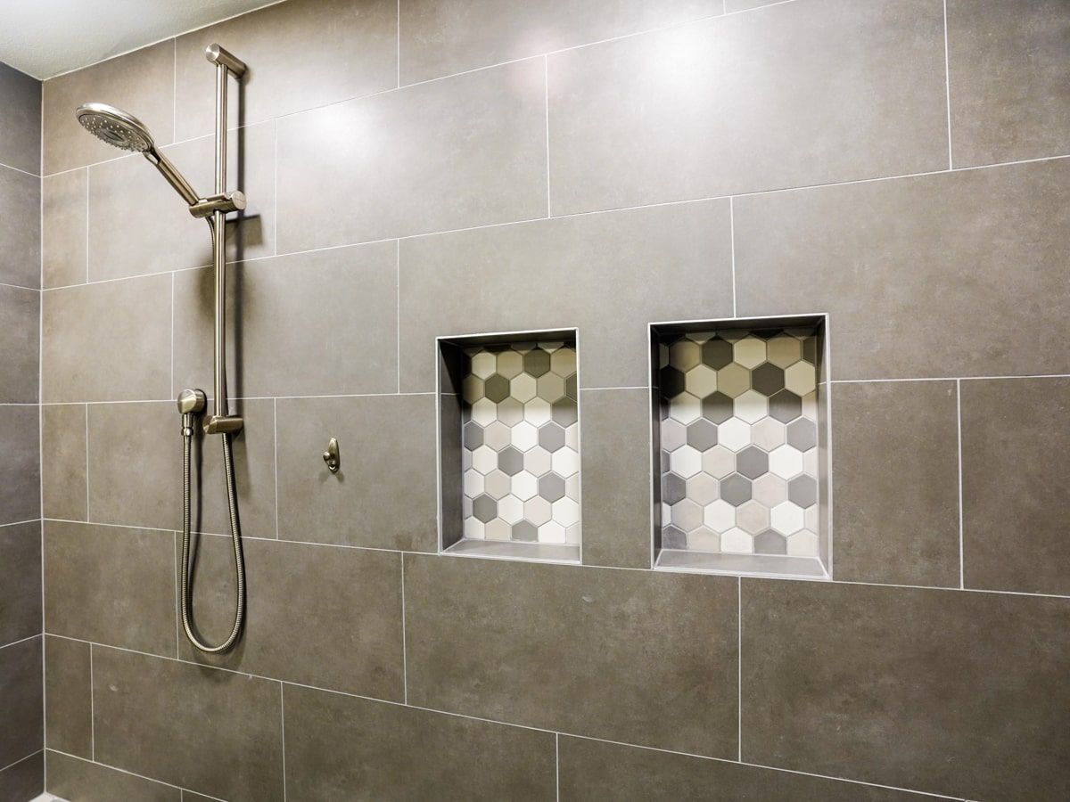 A shower with a shower head and two niches on the wall.