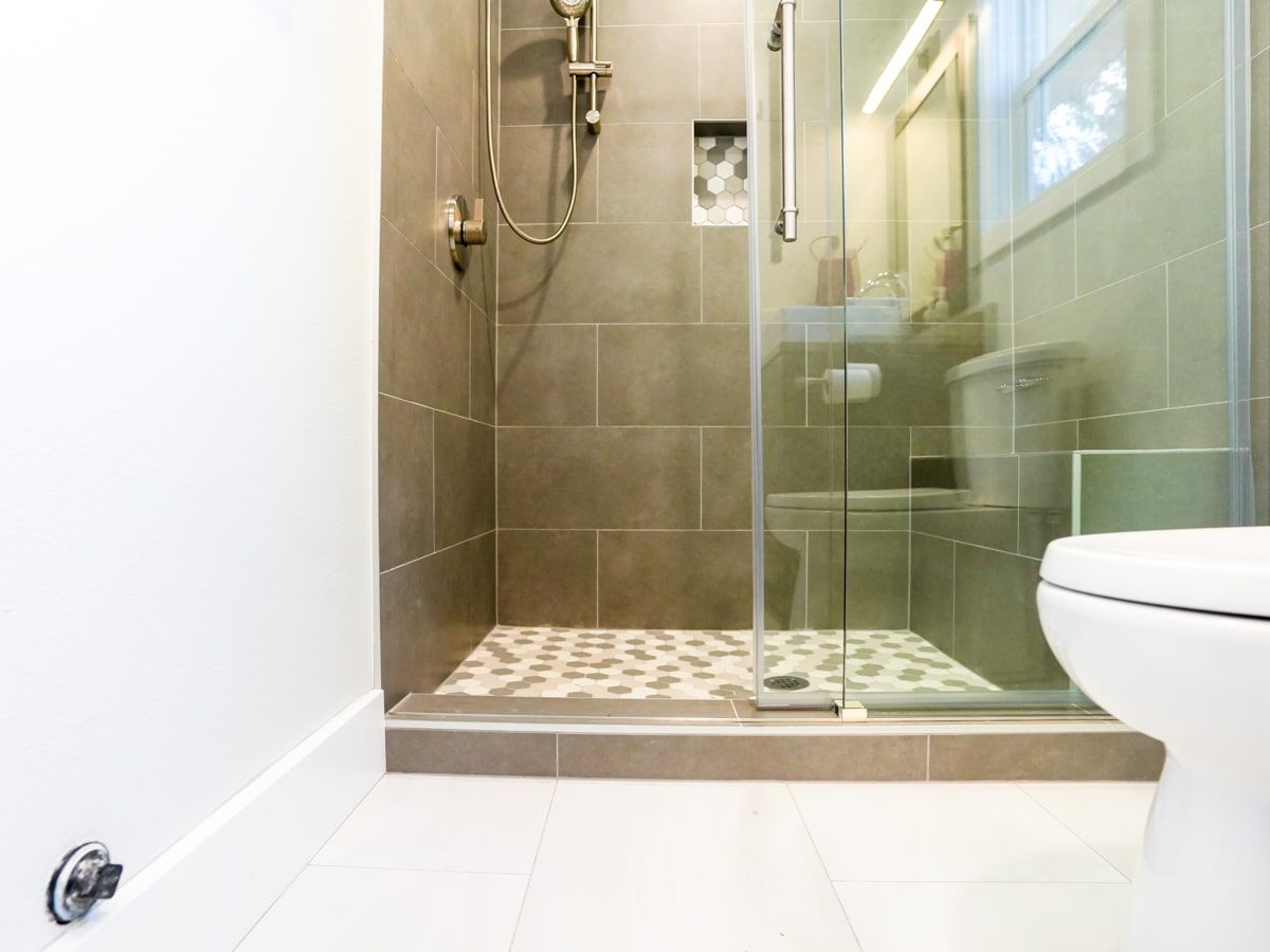 A bathroom with a walk in shower and a toilet.