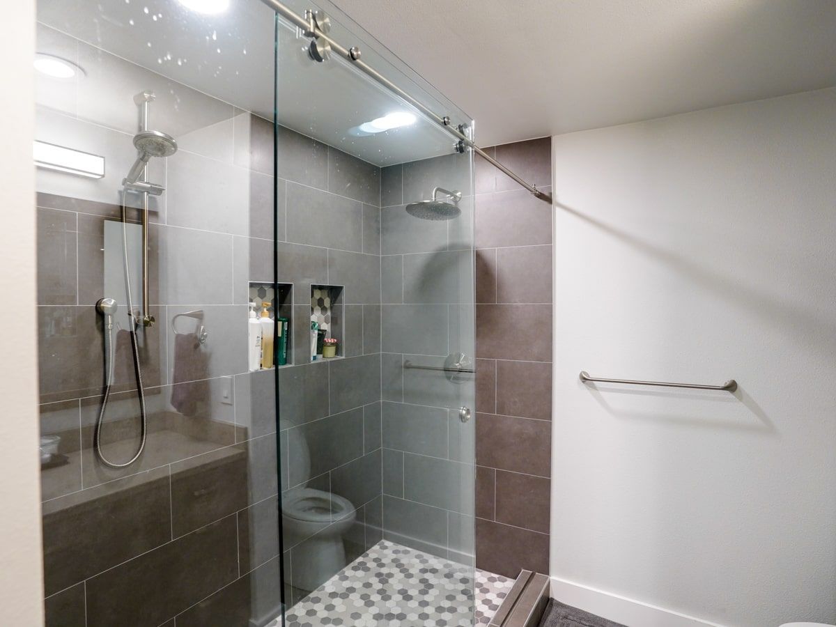 A bathroom with a walk in shower and a toilet.