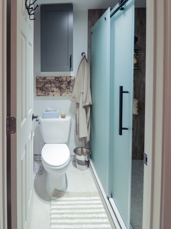 A bathroom with a toilet , sink , and sliding glass doors.