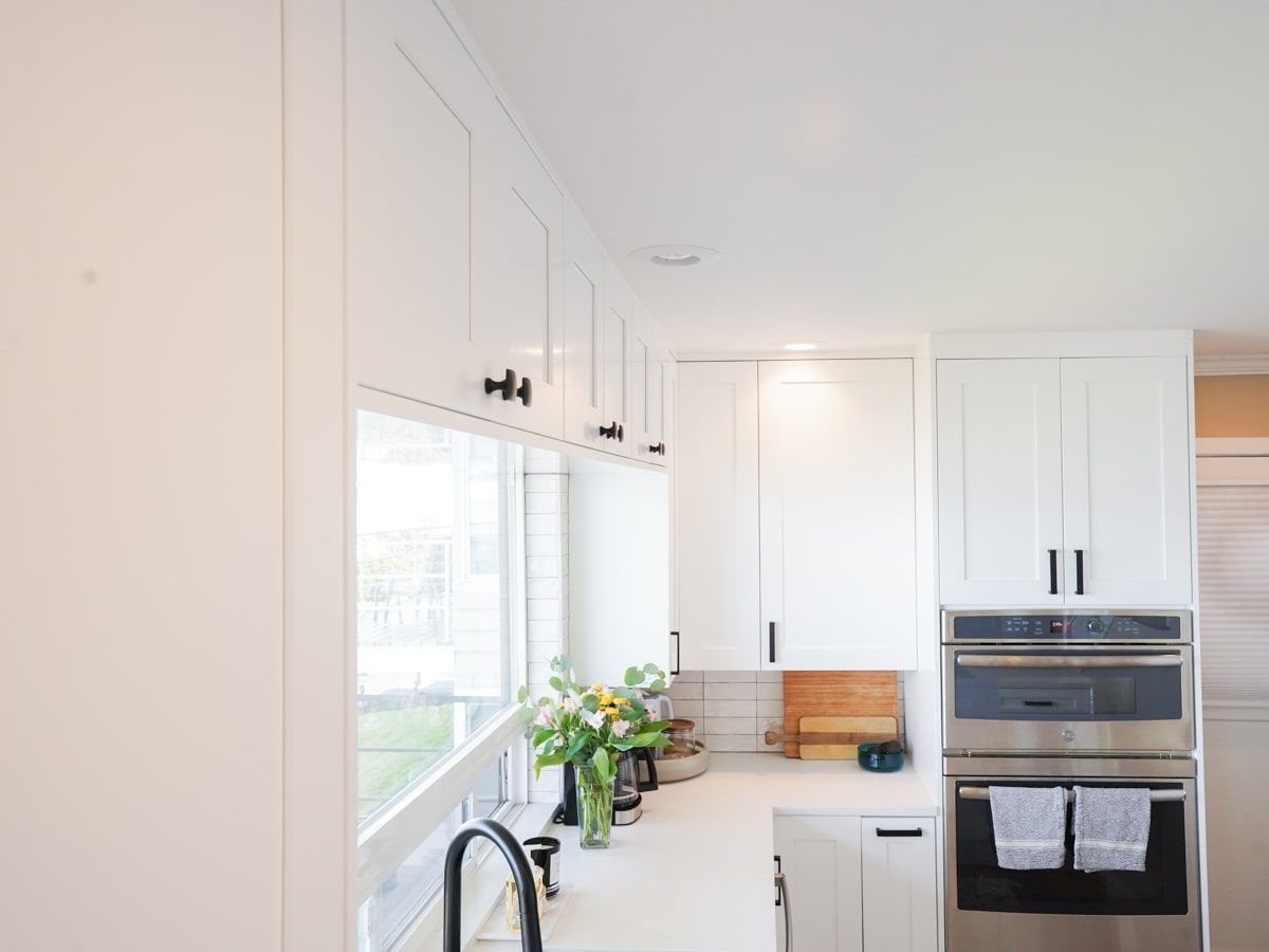 A kitchen with white cabinets and stainless steel appliances