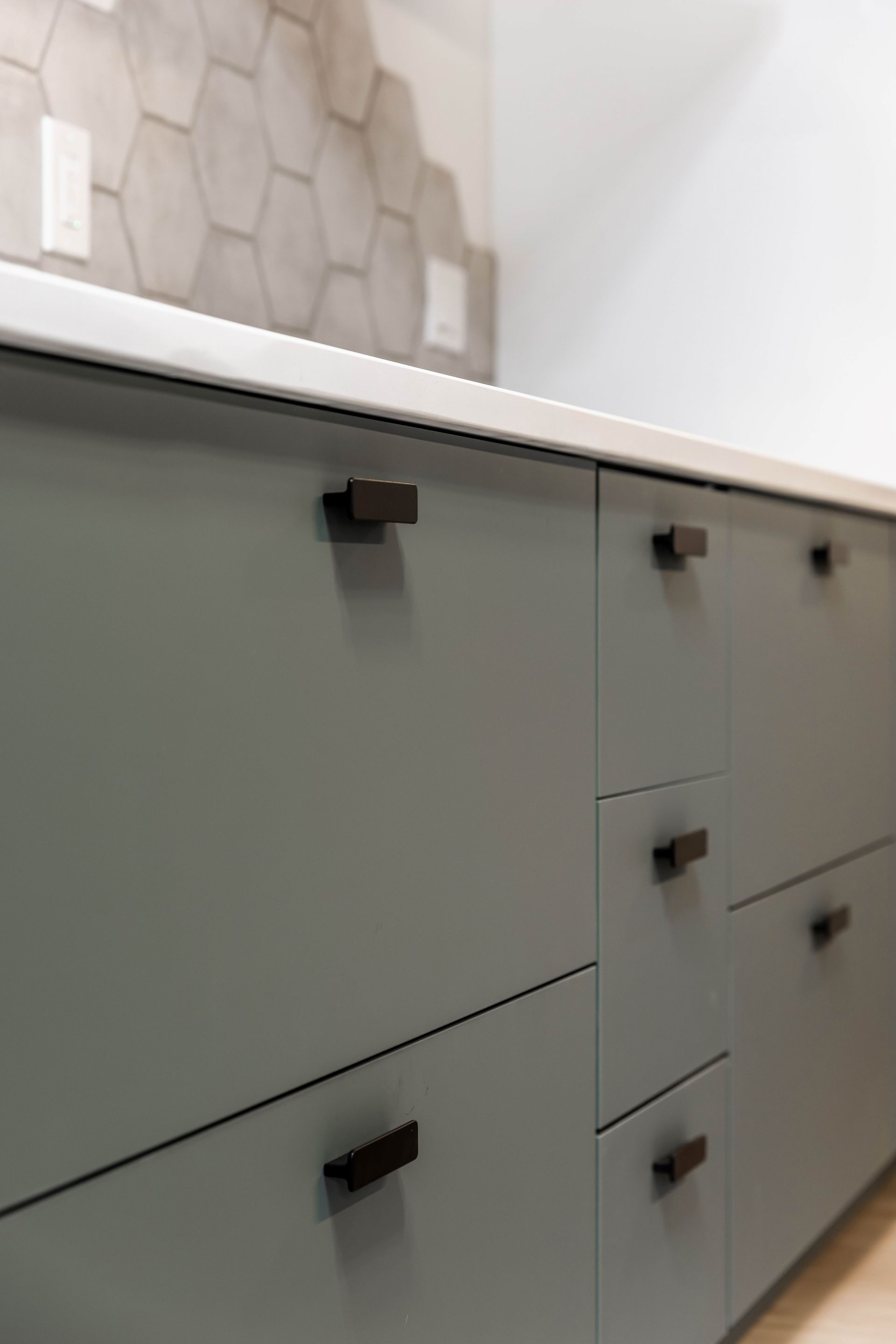 A close up of a kitchen cabinet with drawers and a counter top.