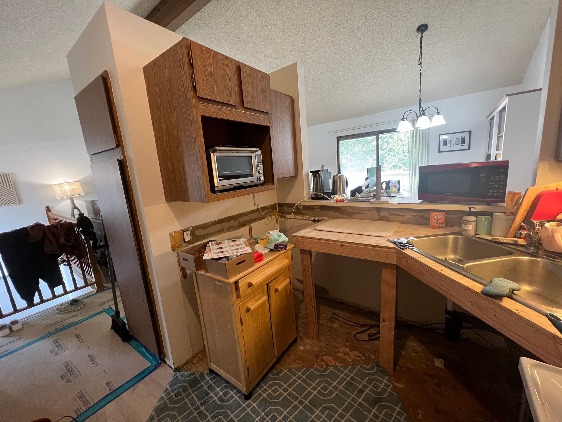 A kitchen with a sink , microwave , and cabinets.