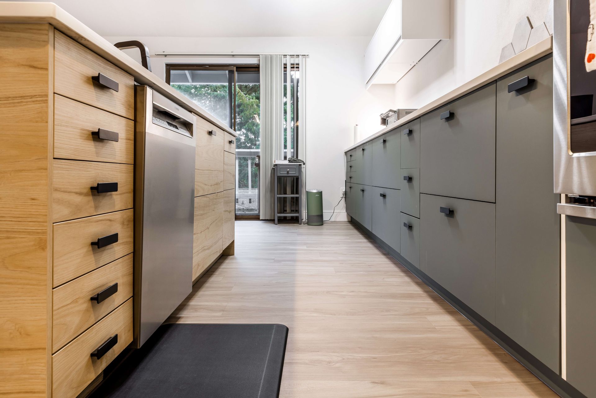 A kitchen with wooden cabinets and a stainless steel dishwasher.