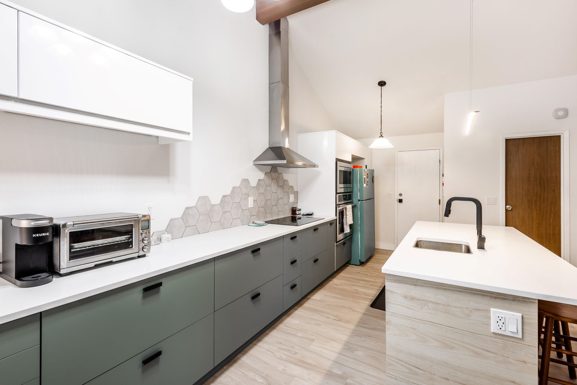 A kitchen with green cabinets and white counter tops