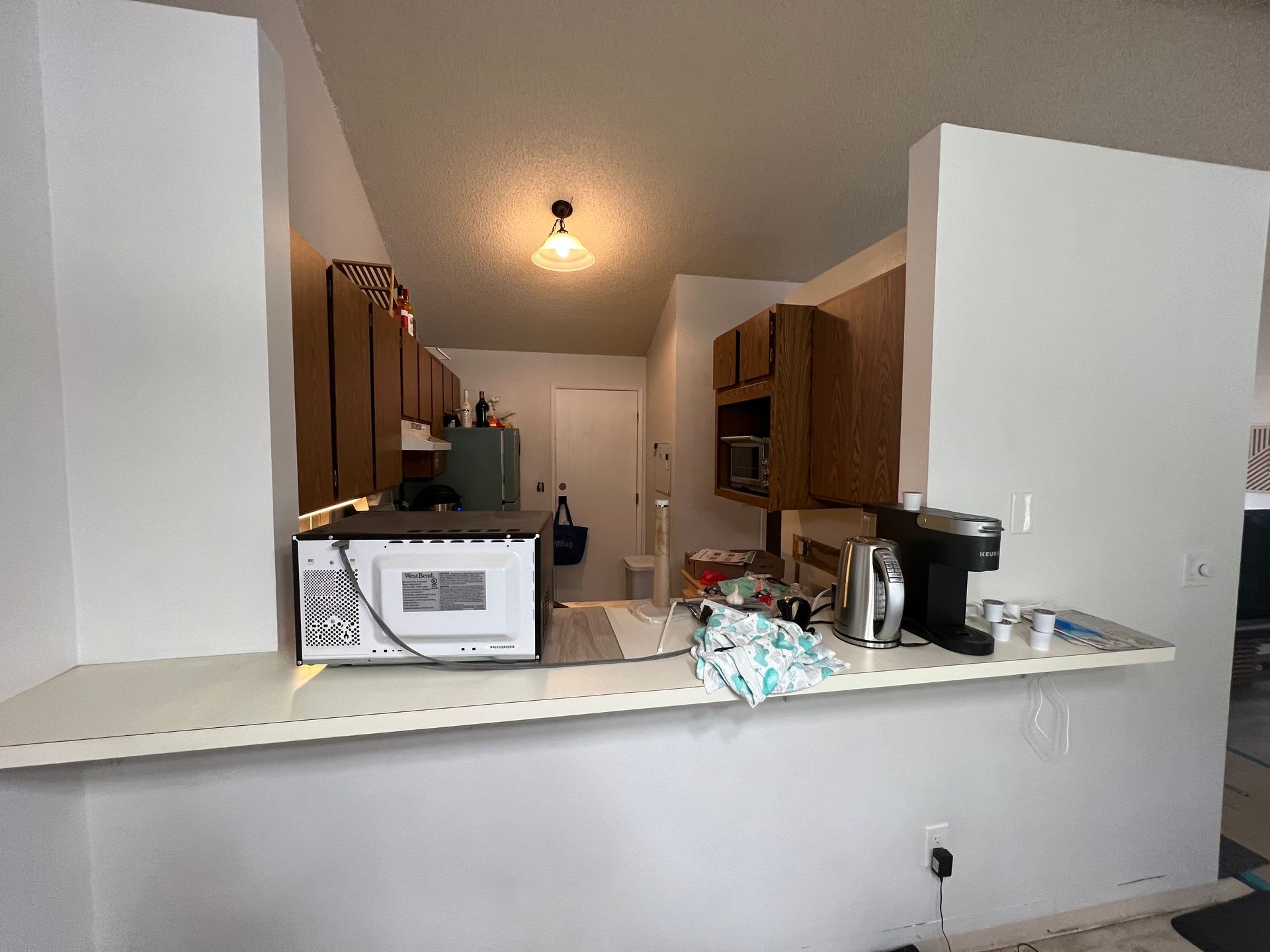 A kitchen with a microwave and a coffee maker on the counter.