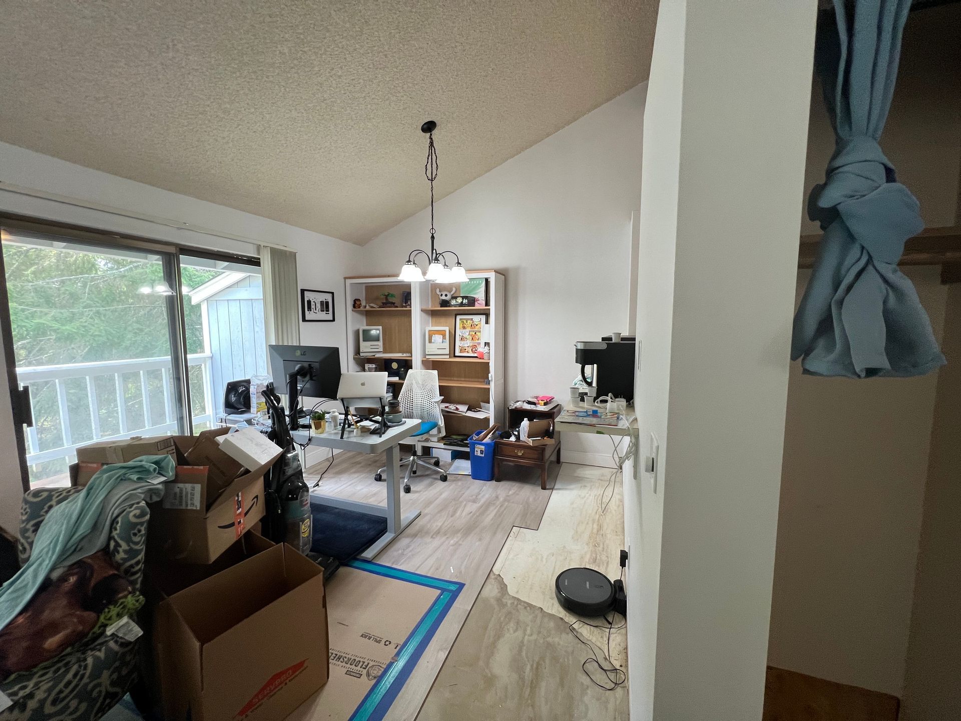 A living room filled with boxes and a desk with a computer on it.