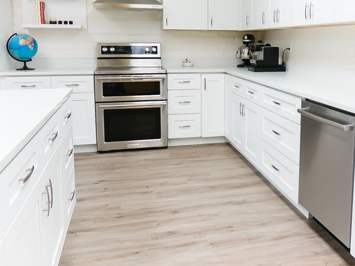 A kitchen with white cabinets and stainless steel appliances