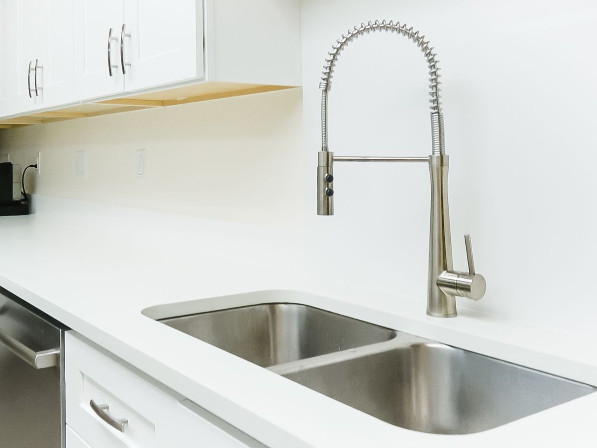 A kitchen with a stainless steel sink and a faucet