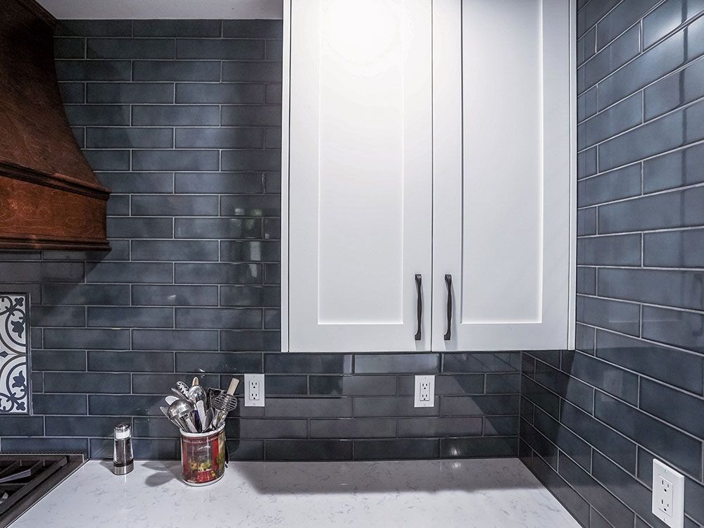 A kitchen with a stove , cabinets , and a hood.