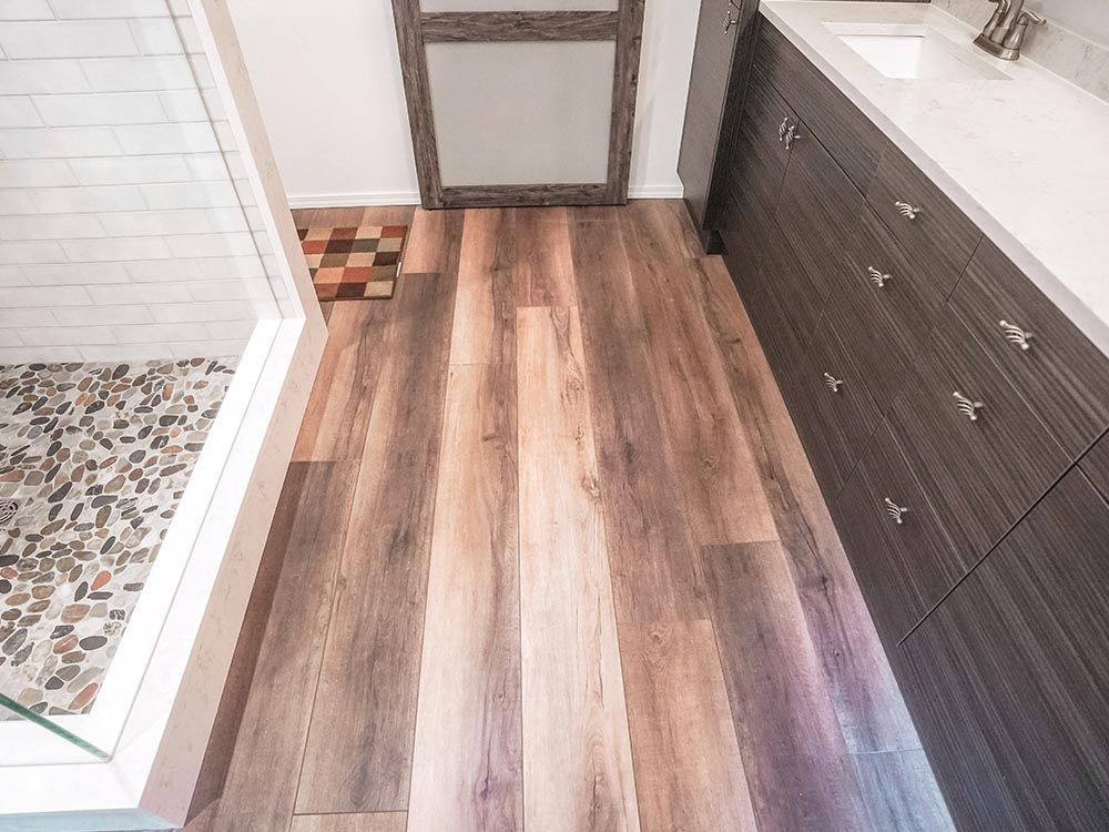 A bathroom with a wooden floor and a walk in shower.