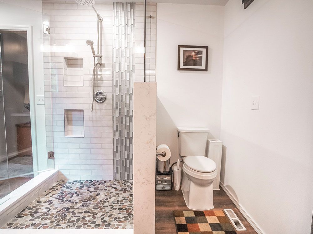 A bathroom with a toilet and a walk in shower.