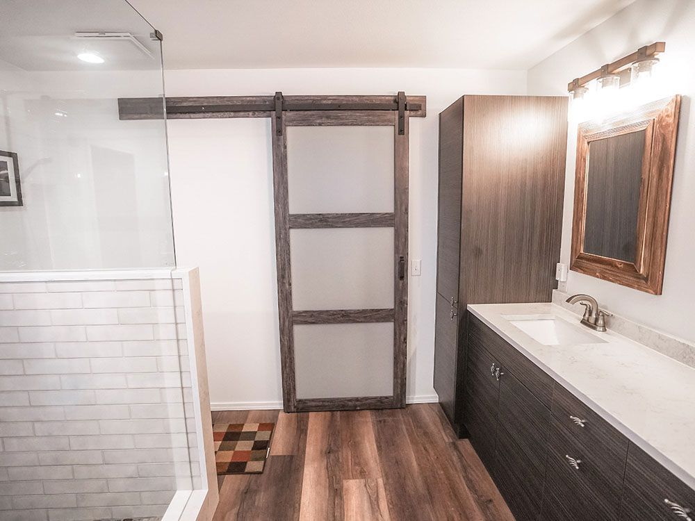 A bathroom with a sliding barn door and a sink