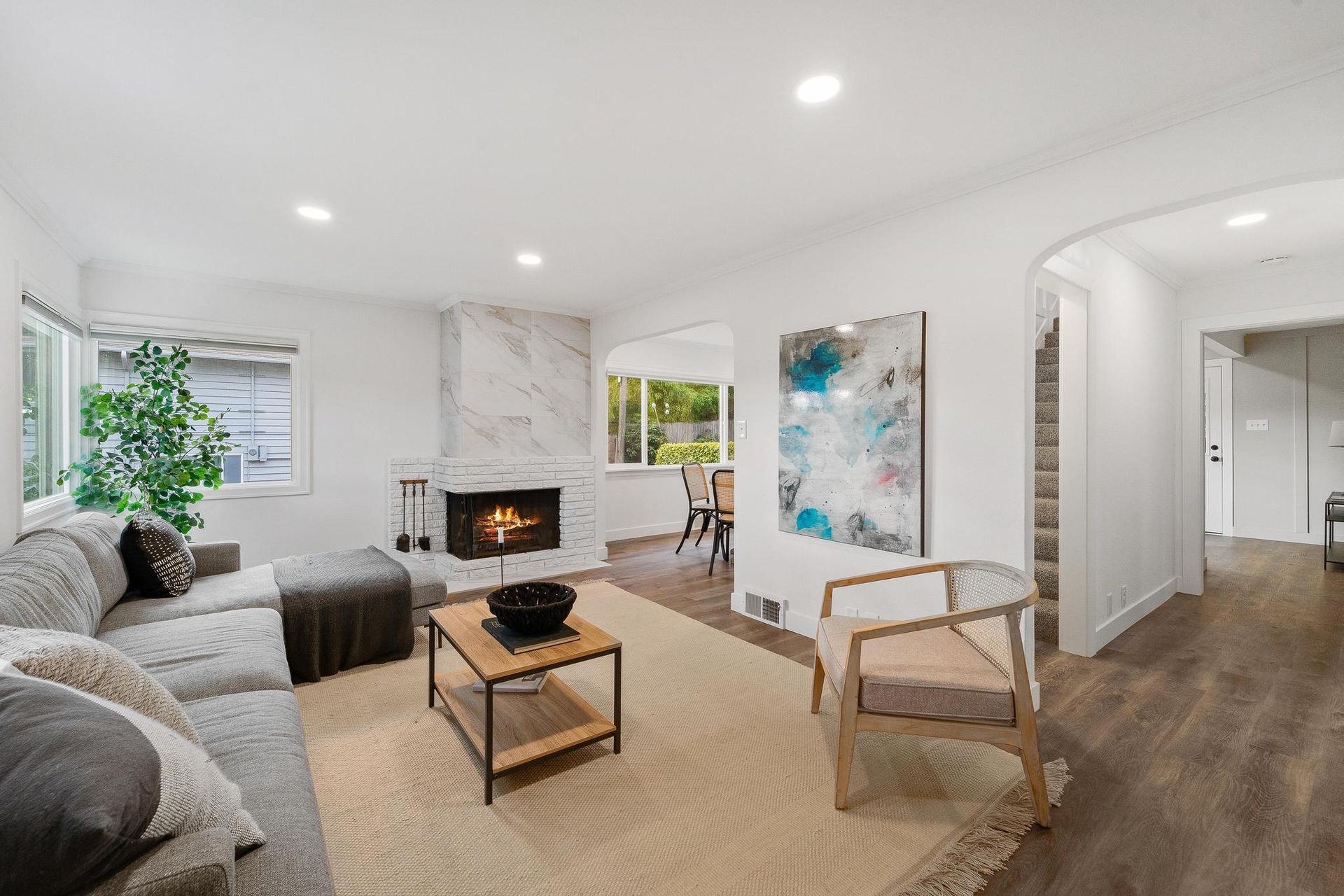 A living room with a couch , chair , coffee table and fireplace.