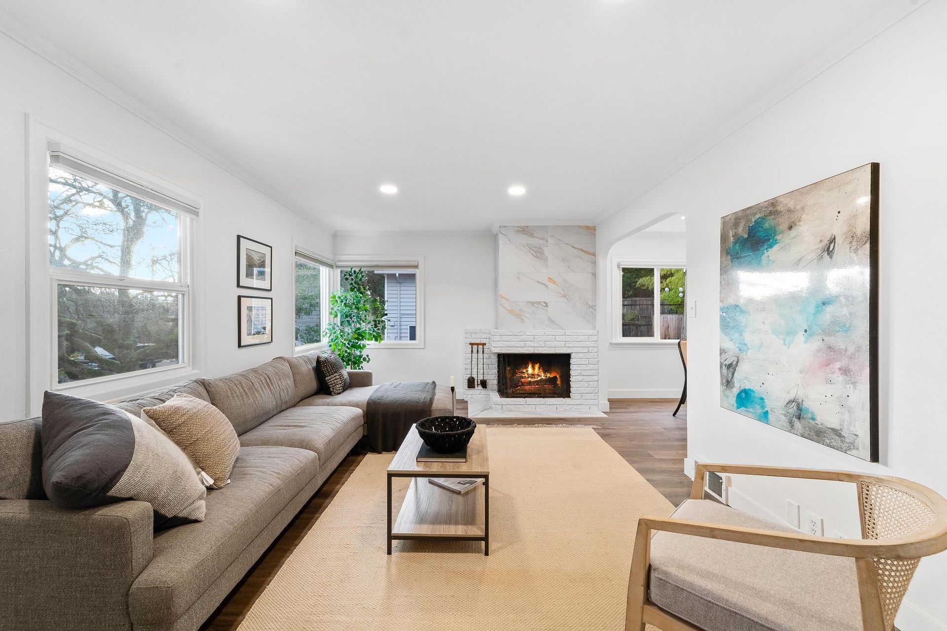 A living room with a couch , chair , coffee table and fireplace.