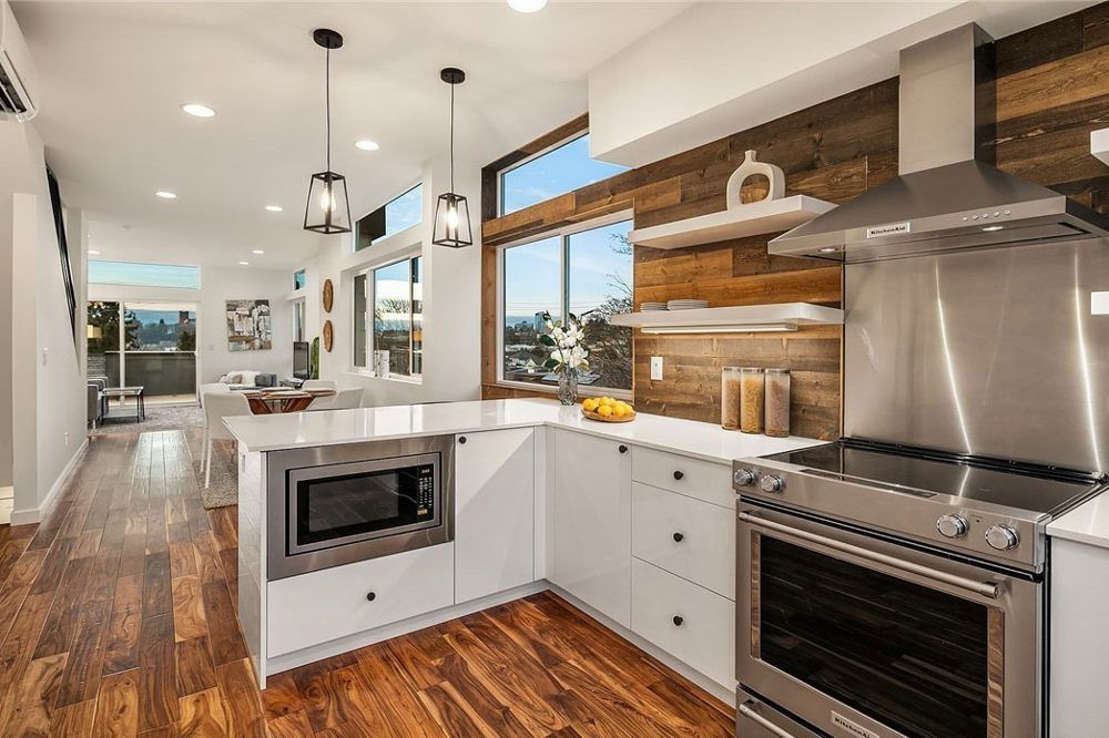 A kitchen with stainless steel appliances and wooden floors.