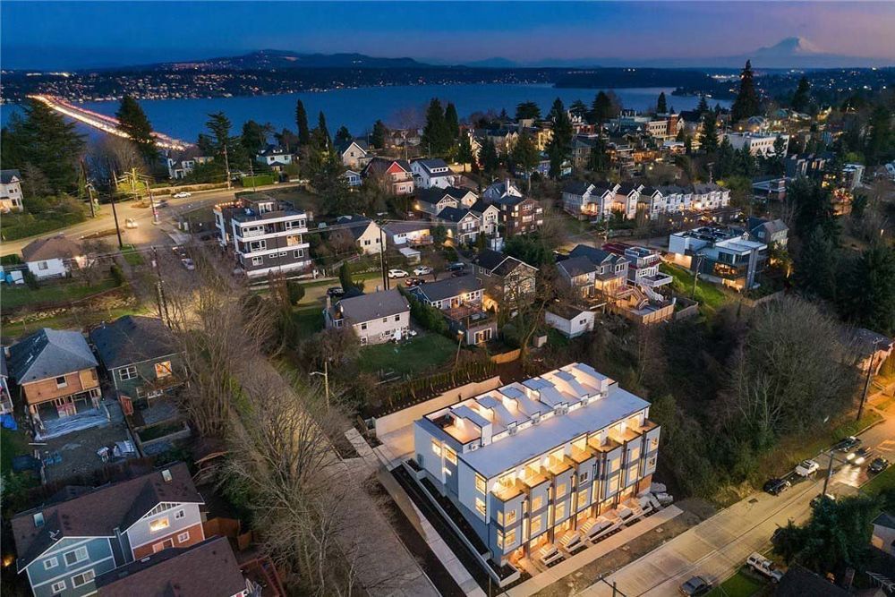 An aerial view of a city at night with a building in the foreground.