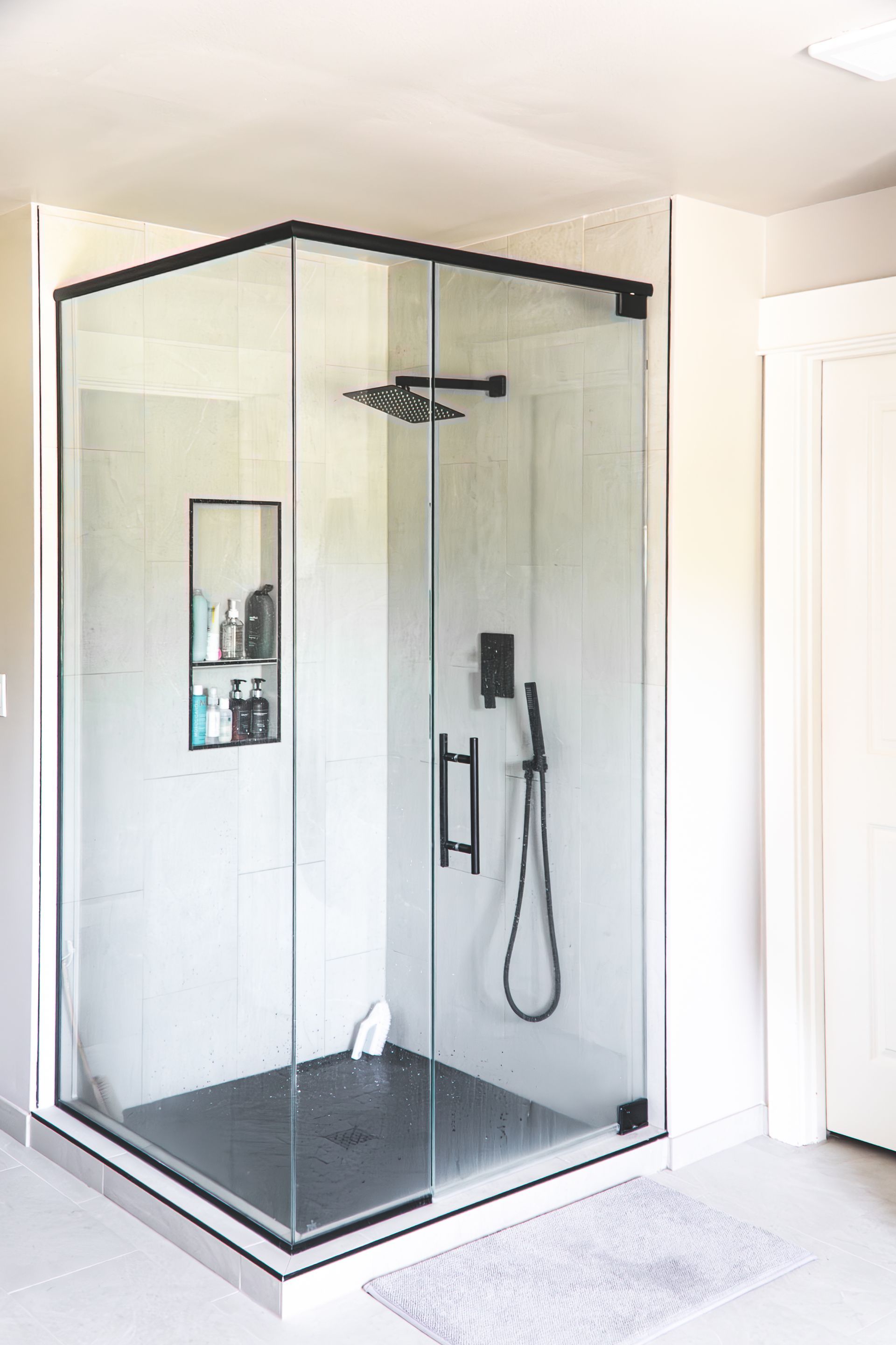 A bathroom with a glass shower stall and a shower head.