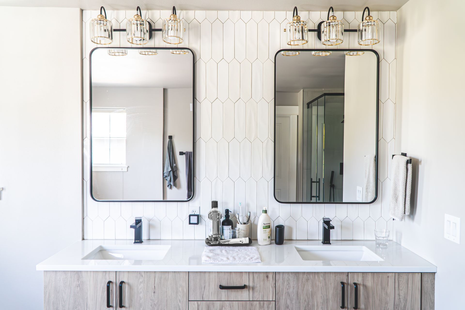 A bathroom with two sinks and two mirrors.