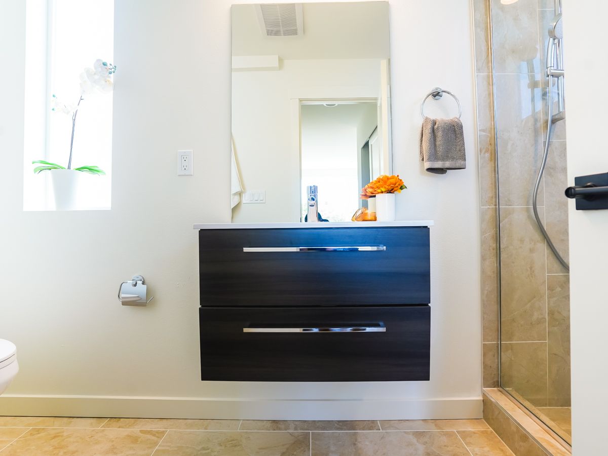 A bathroom with a sink a mirror and a walk in shower