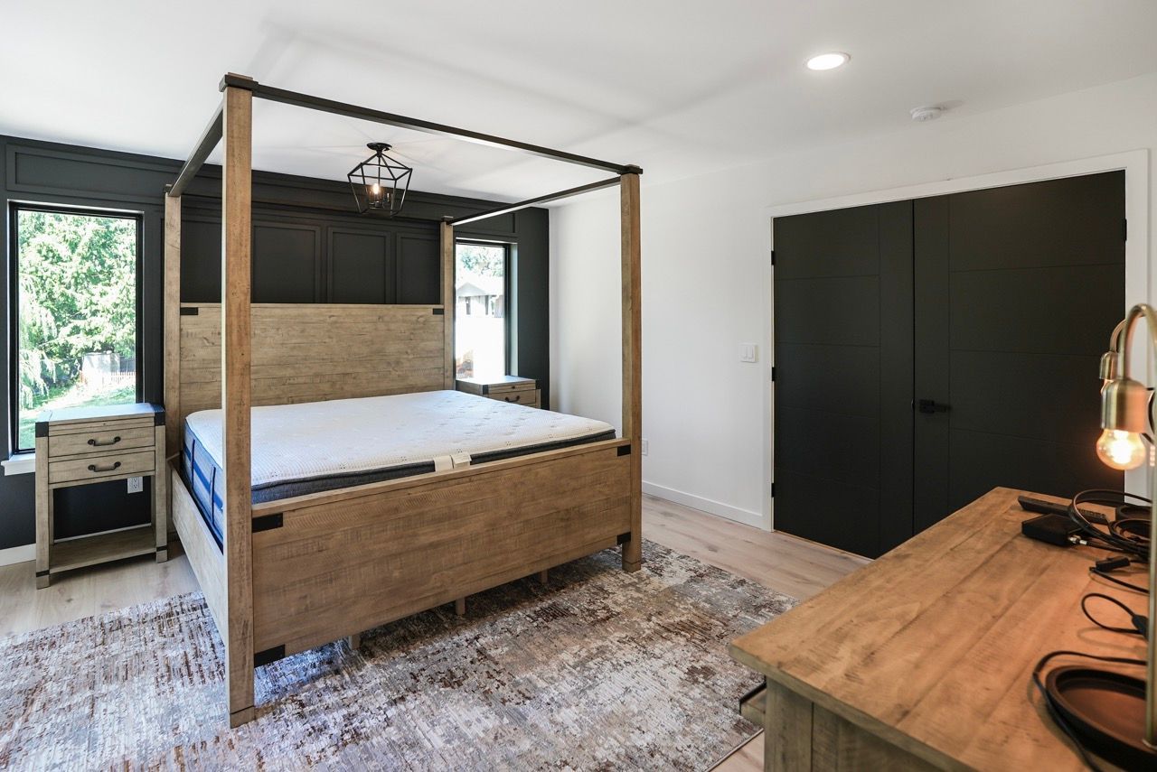 A bedroom with a canopy bed and a rug.