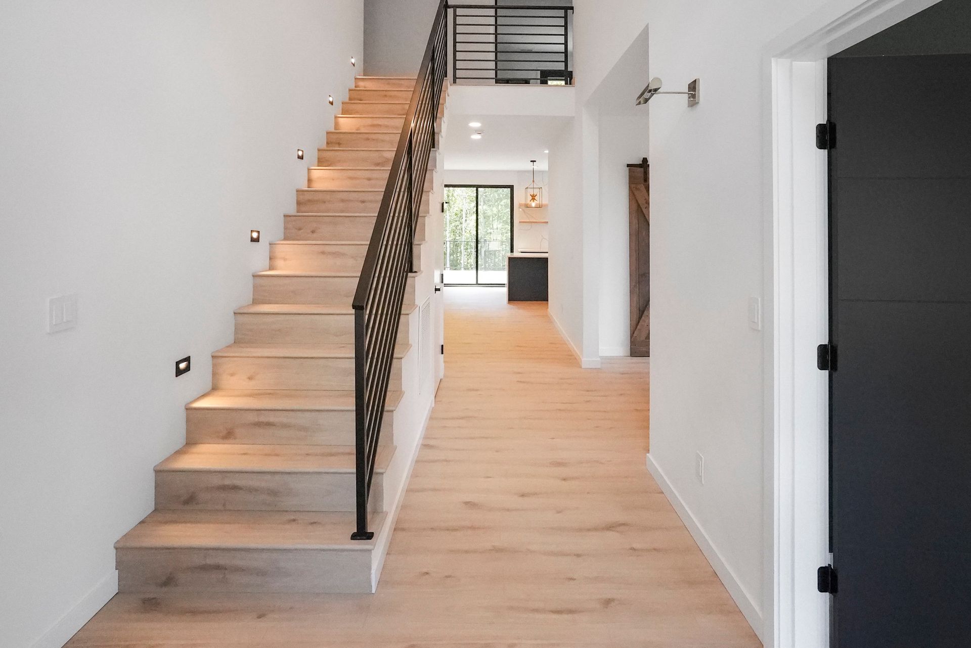 A hallway with stairs leading up to the second floor