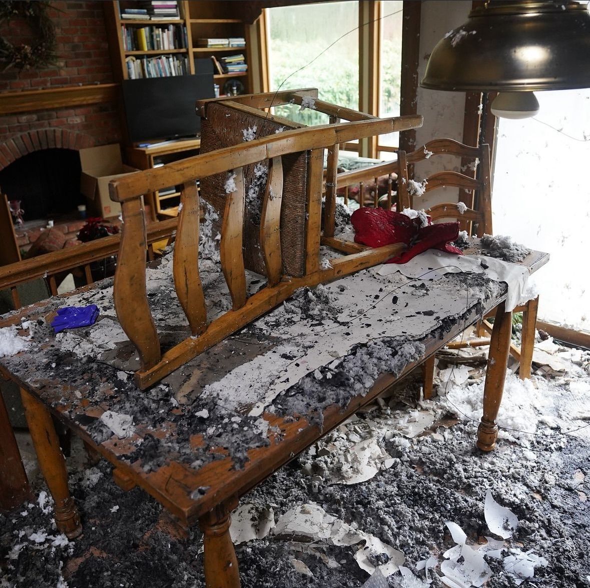 A table and chairs are covered in ash in a living room