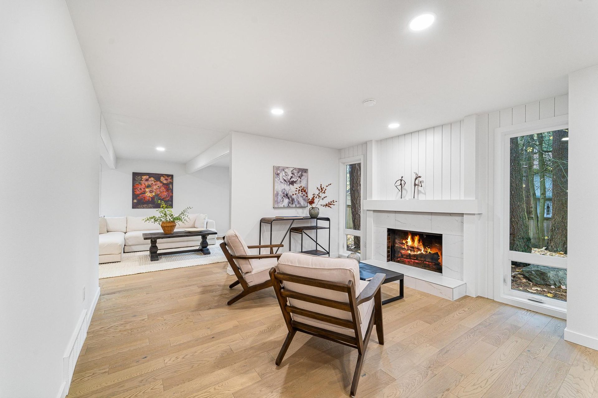 A living room with a fireplace , chairs , a table and a couch.