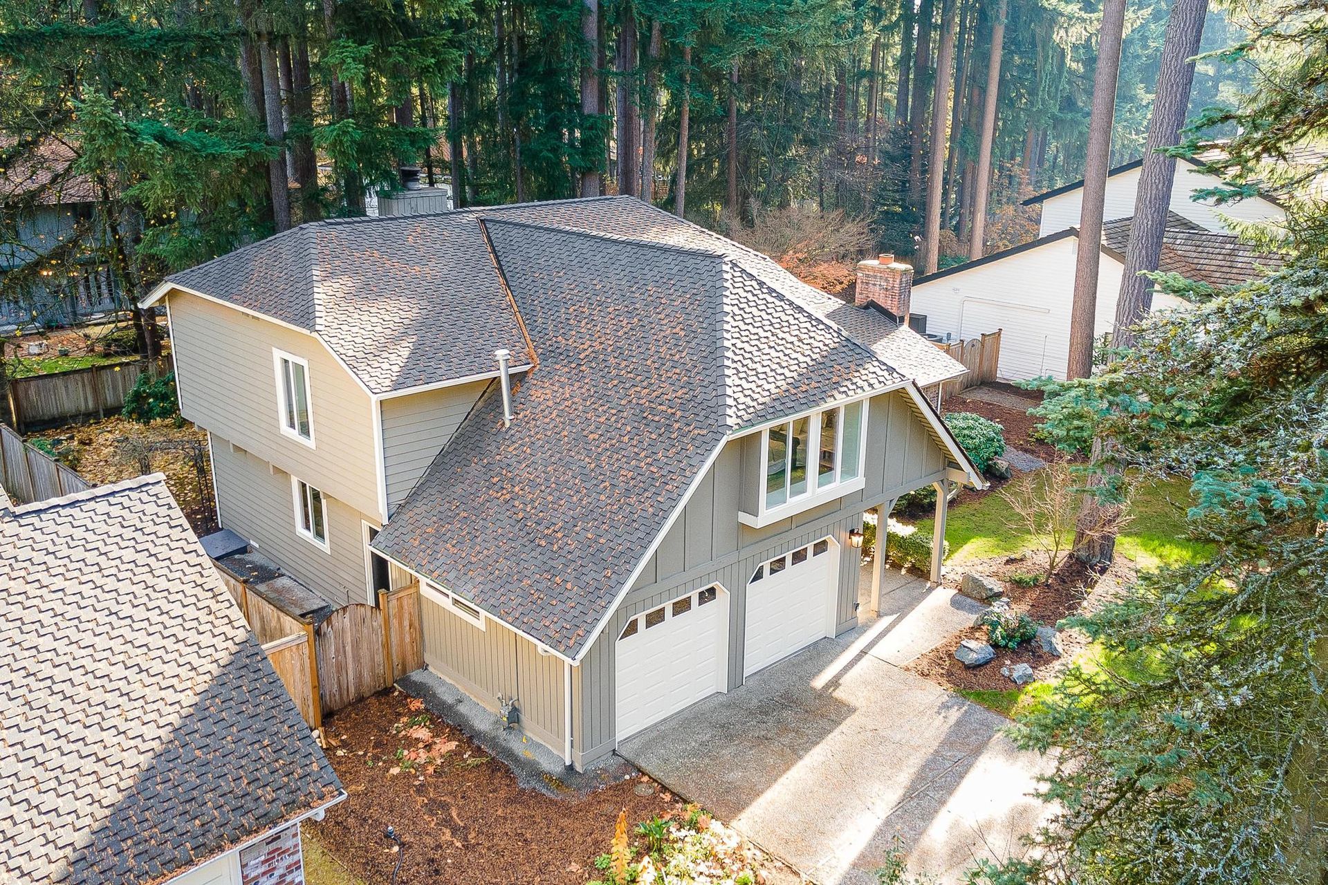 An aerial view of a house in the middle of a forest.
